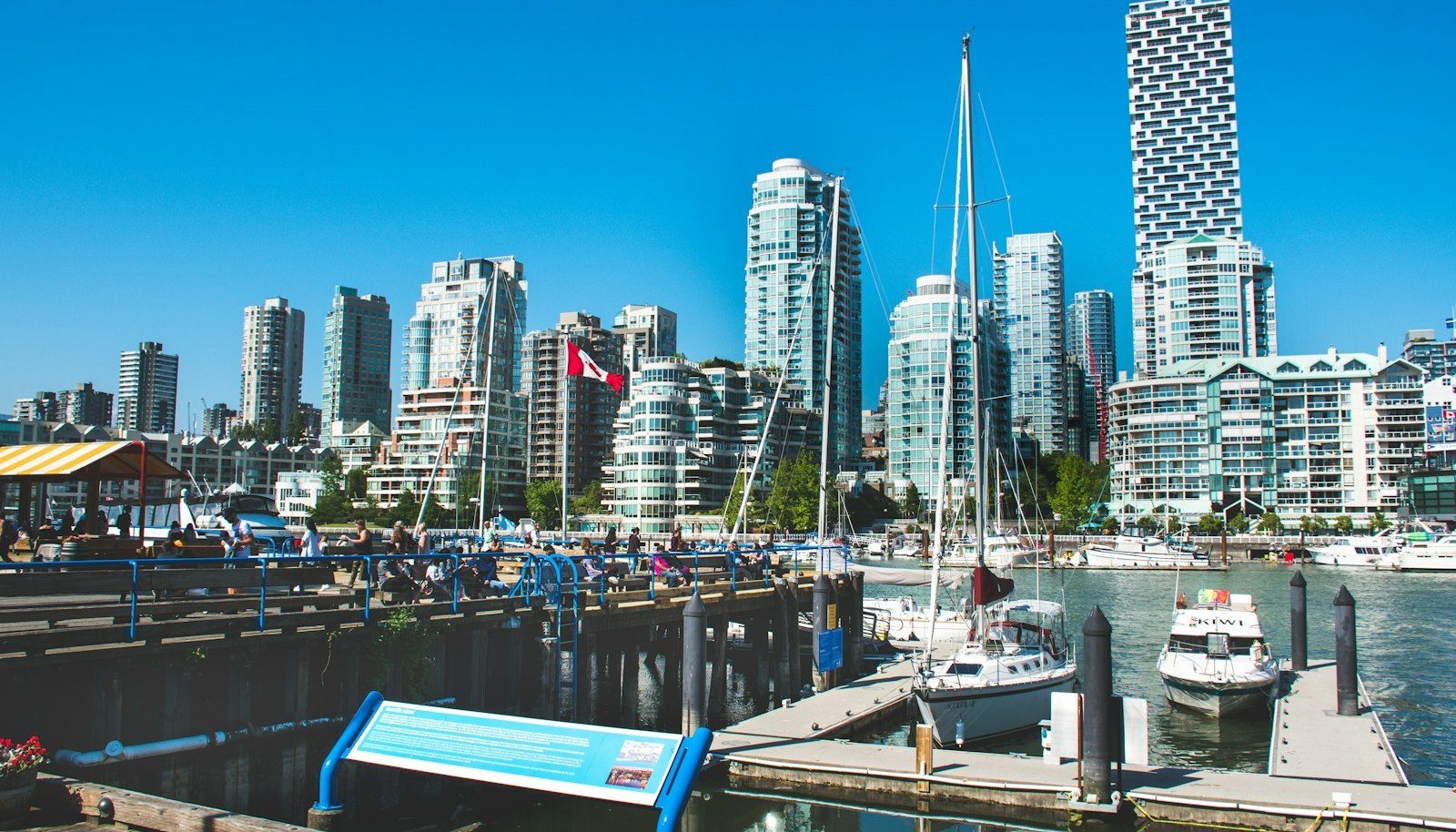 Sailboats moored at the Granville Island docks, with the glass towers of downtown Vancouver across False Creek