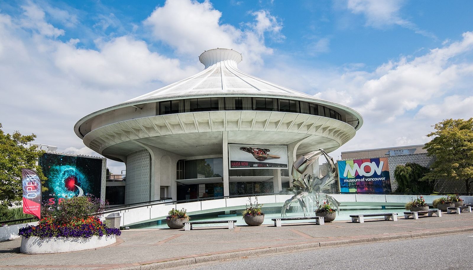 The round, flying-saucer-shaped H.R. MacMillan Space Centre building in Vanier Park under a blue sky