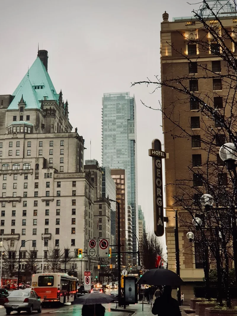 Парасольки на West Georgia Street біля вивіски Hotel Georgia і зеленого даху Fairmont Hotel Vancouver