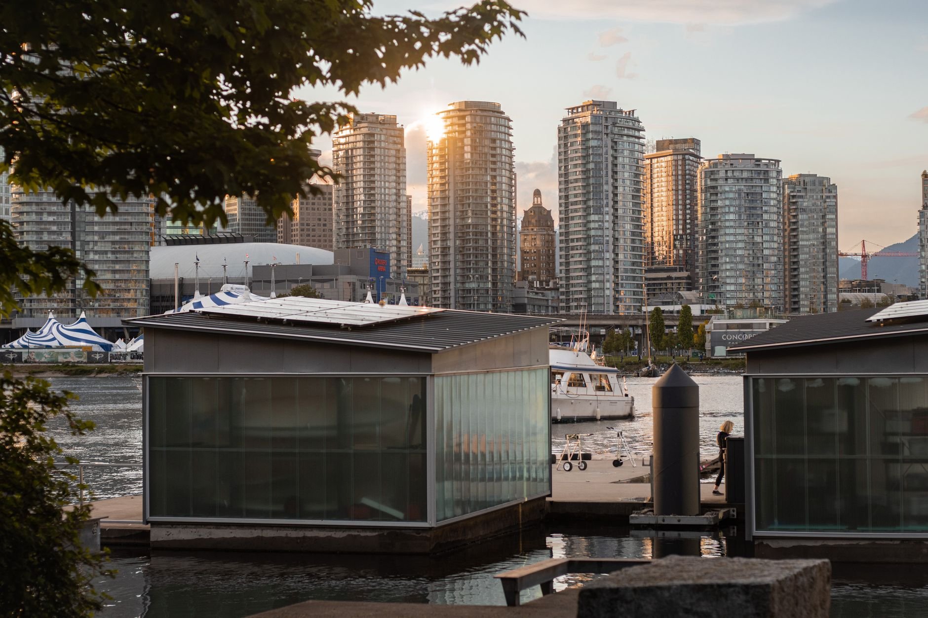 Residential towers catching the low sun above floating homes moored in the foreground