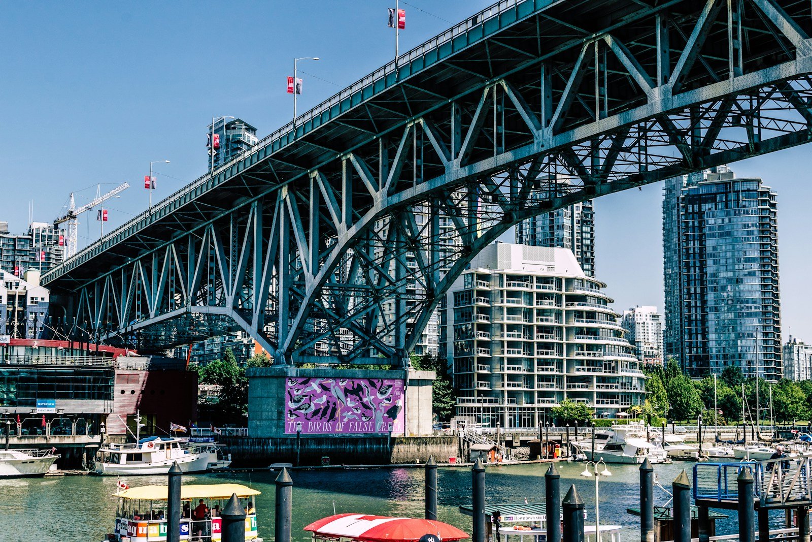 The steel truss of the Granville Bridge above Granville Island, with downtown towers behind
