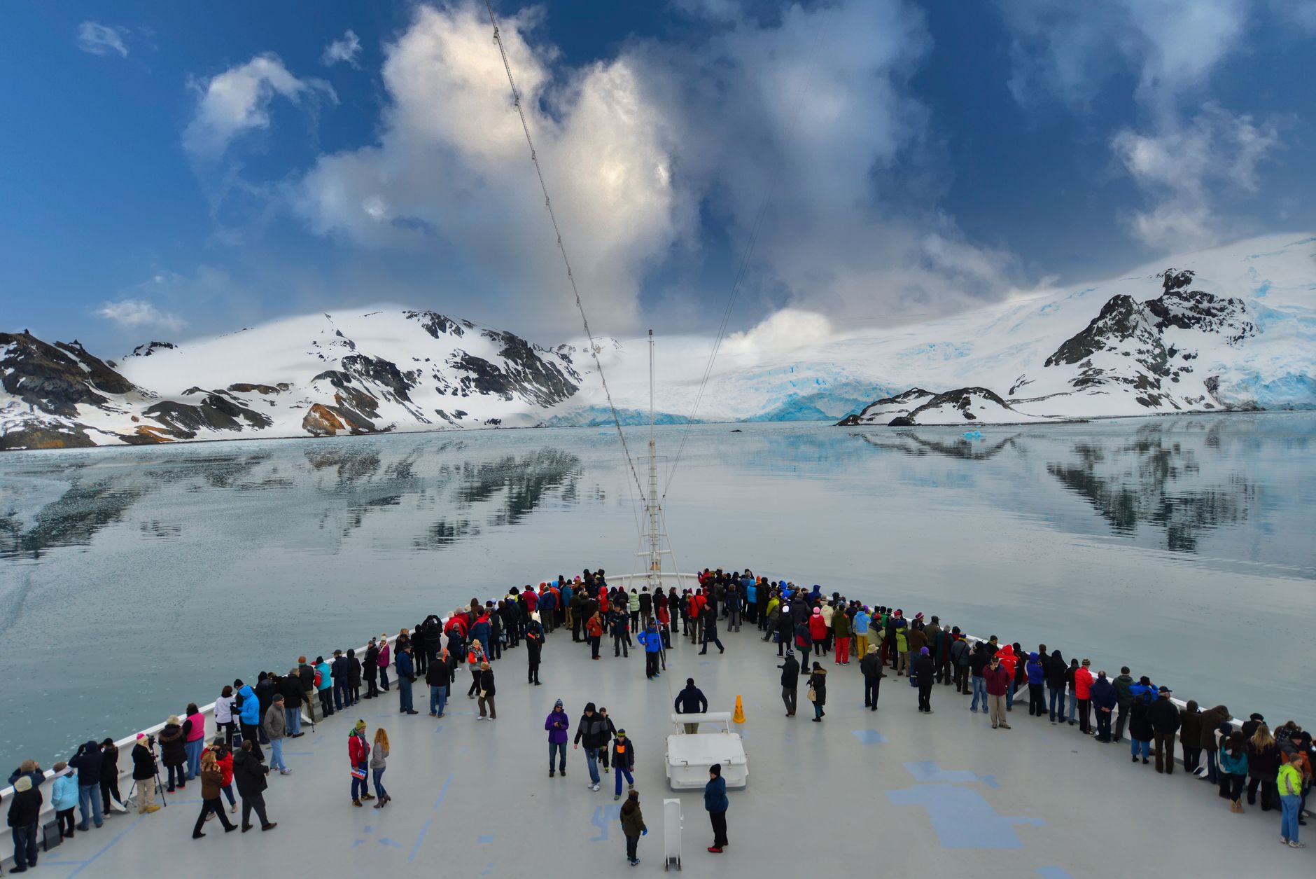 Cruise passengers on deck watching glaciers and snow-capped mountains