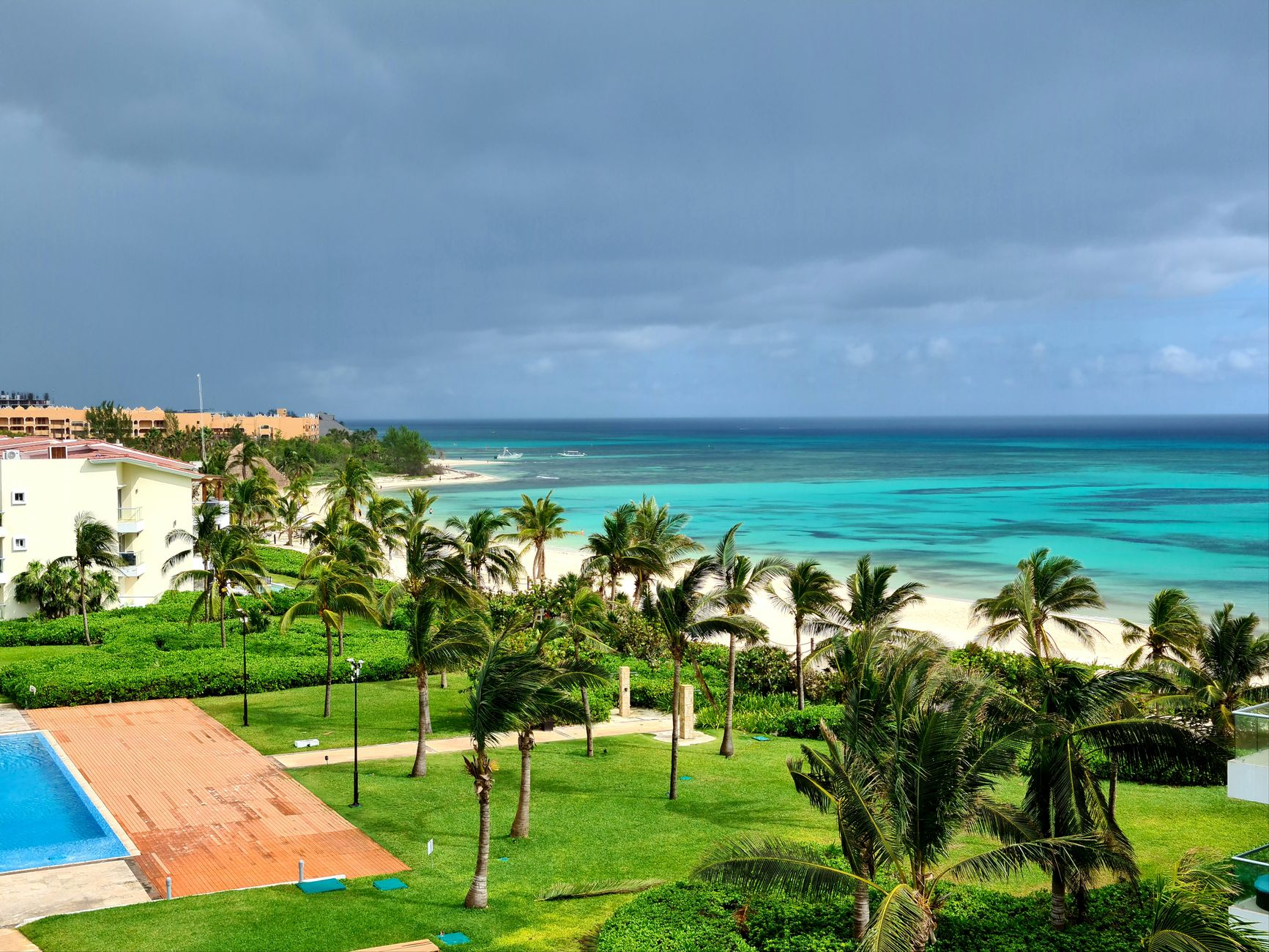 Beachfront resort with a pool, palms and turquoise ocean