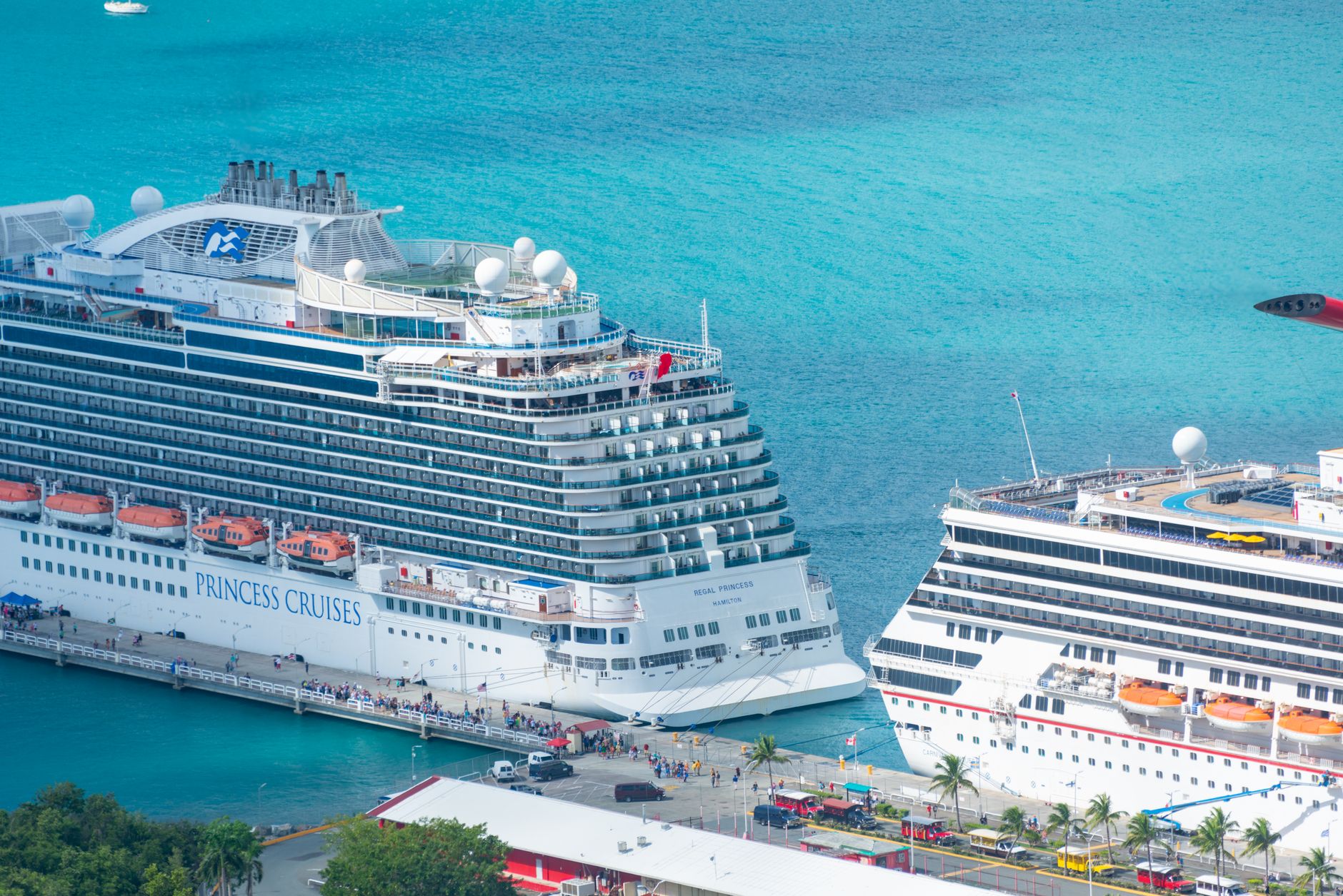 Cruise ships docked at a tropical Caribbean port with turquoise water